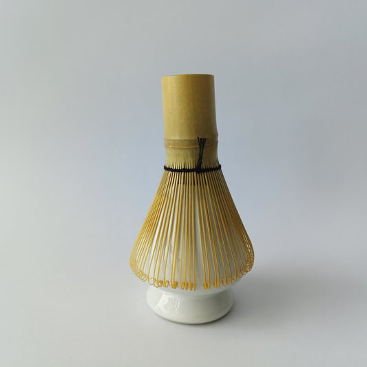 Bamboo whisk on a white base against a gray background